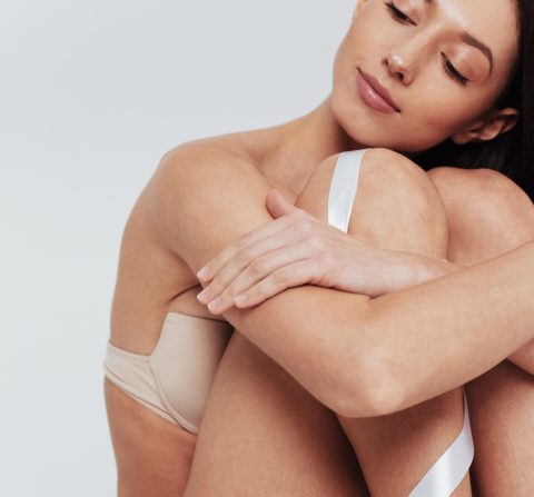 woman sitting with her hands around her knees