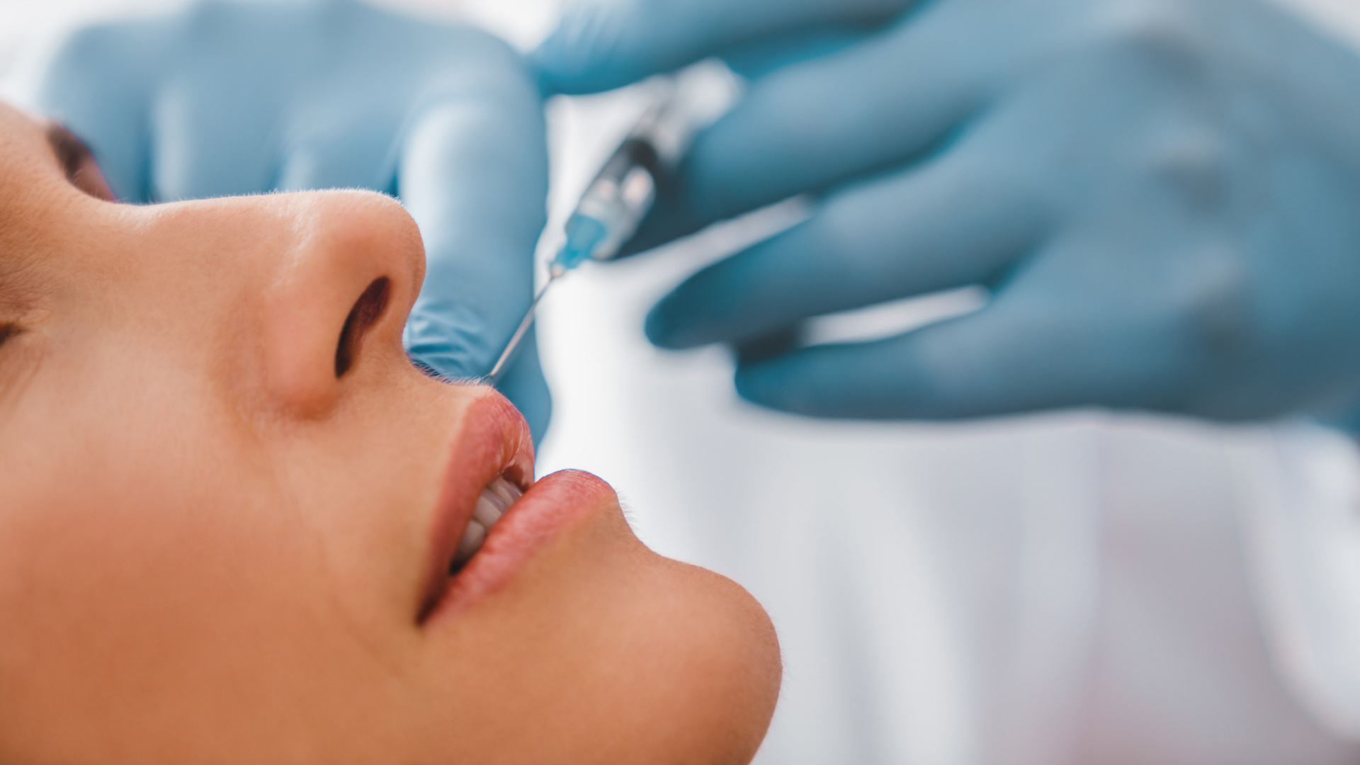 white women getting an injection into her lips