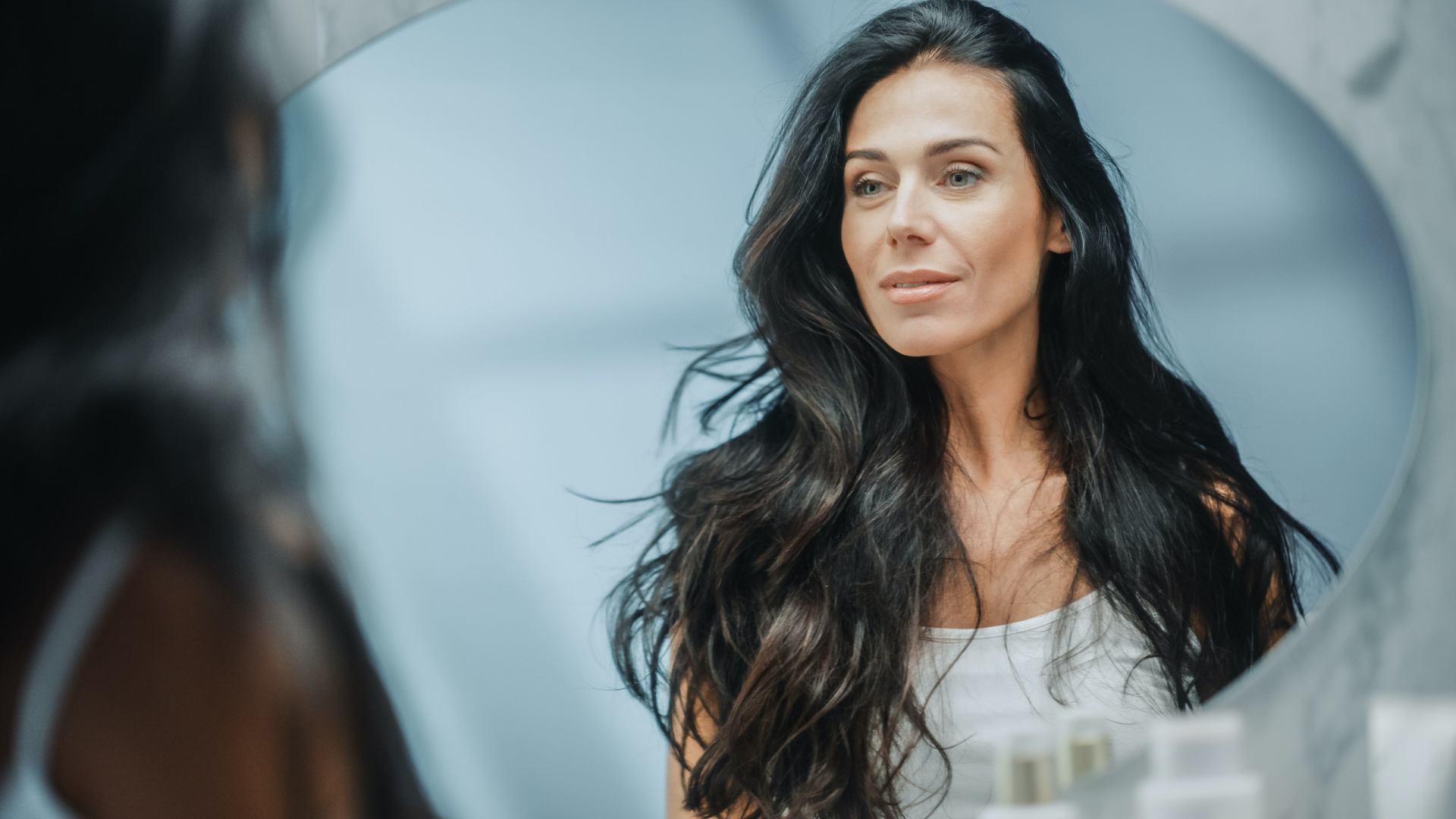 Woman with black hair looking past the camera