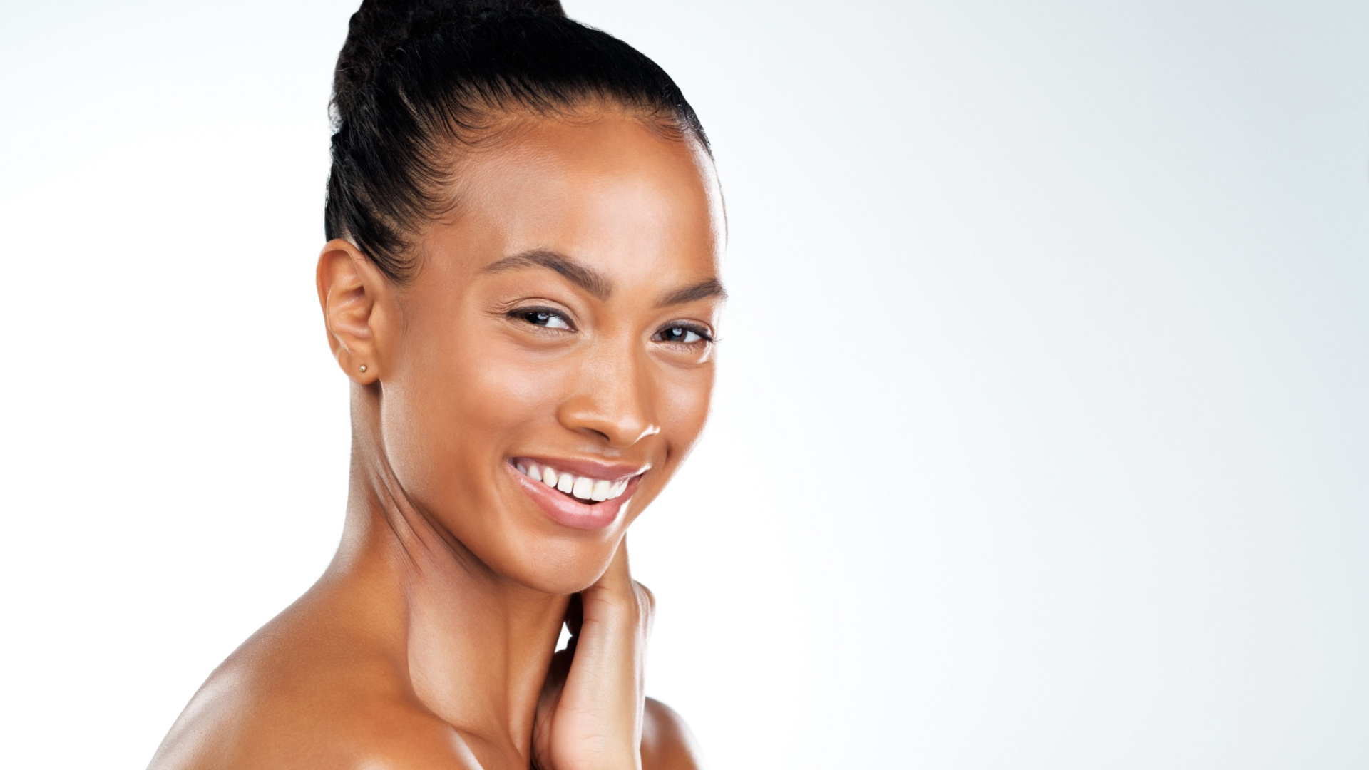 african american women smiling at the camera with her hand on her neck