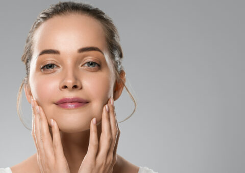 Woman with smooth, lifted skin gently touching her face after a PDO thread lift treatment, showcasing natural facial rejuvenation and firmness.