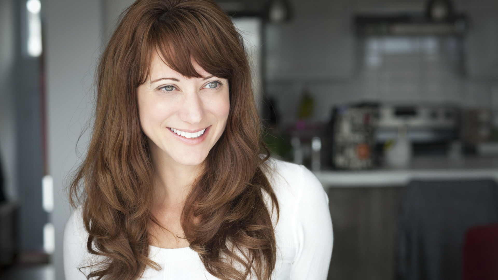 woman with brown hair smiling after getting Juvederm