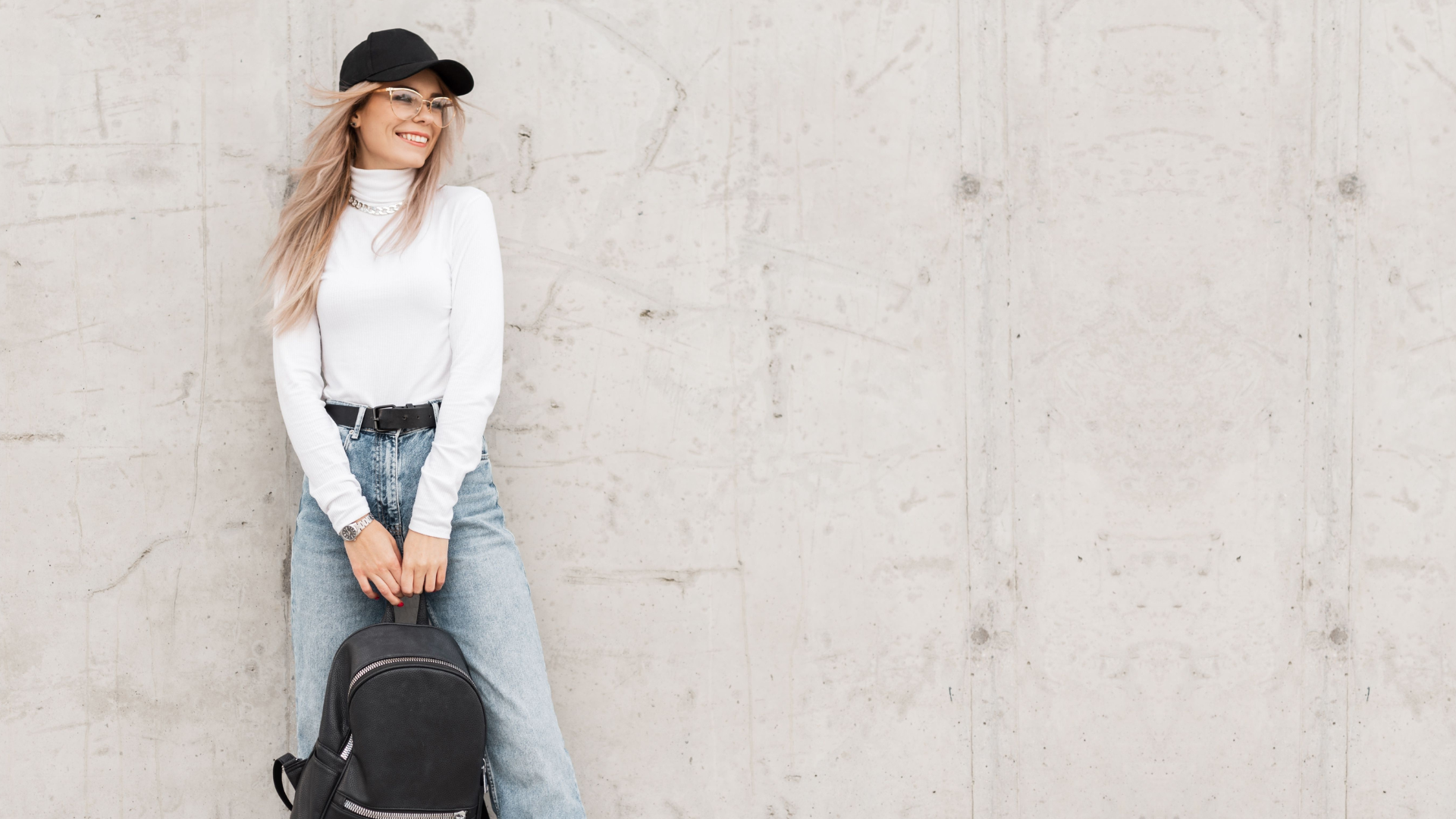 woman smiling and holding a backpack