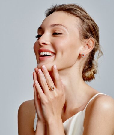 women laughing and touching her chin with a gray background