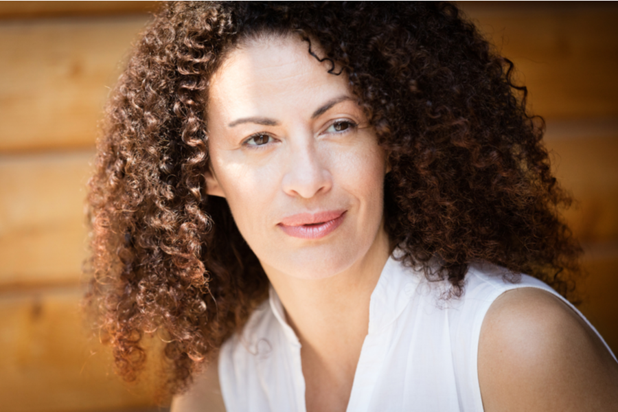 beautiful older woman with curly hair looking pensive