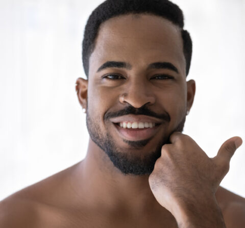 man looking in the mirror after laser treatments