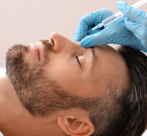 man laying down getting work done on his face