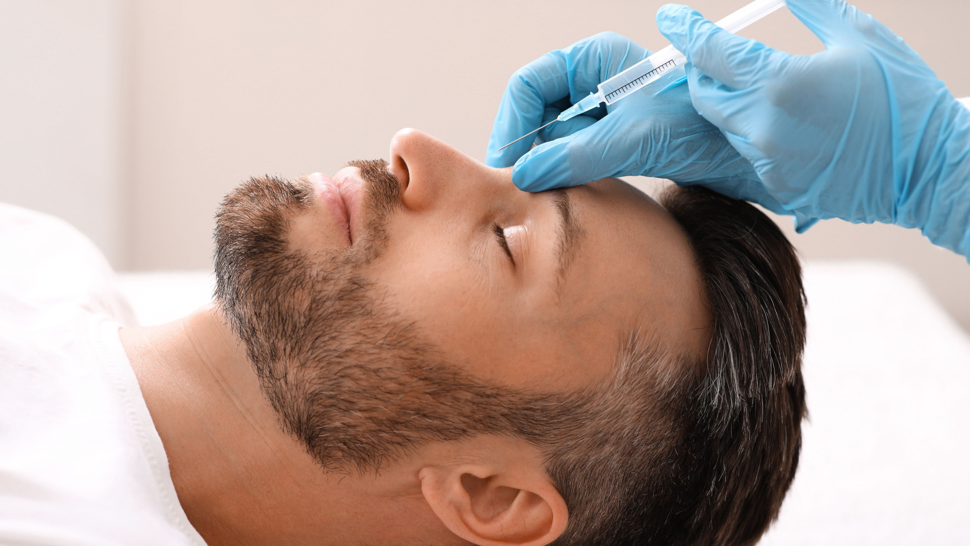 man laying down getting work done on his face