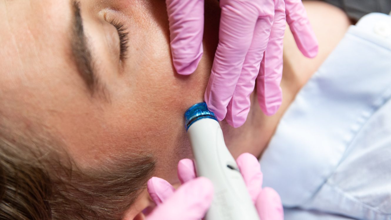 man getting HydraFacial by doctor