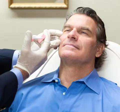 white man getting an injection into his cheek