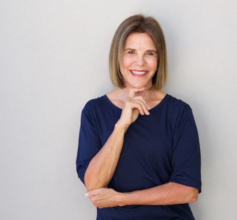 older woman smiling with hand to chin