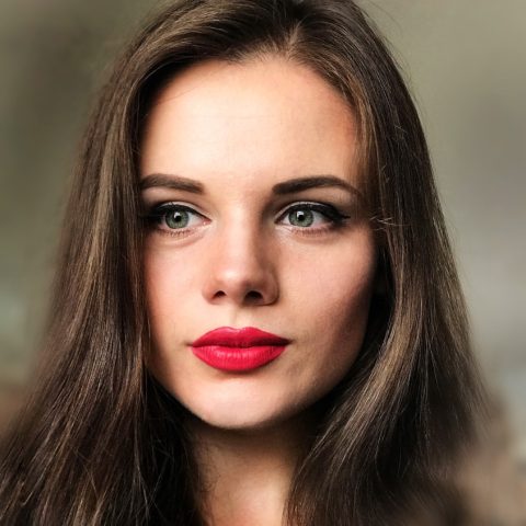 woman with long brown hair and bright red lipstick
