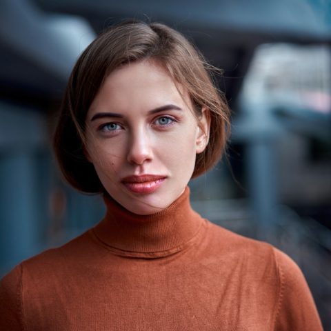 women looking at the camera with a straight face and orange shirt