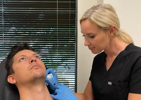Male patient receiving a facial treatment from a provider wearing blue gloves