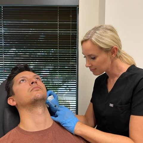 Male patient receiving a facial treatment from a provider wearing blue gloves