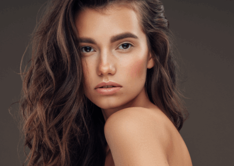 Woman with smooth, radiant skin and long wavy hair, showcasing the bright, even-toned complexion often achieved with BBL photofacial treatment.