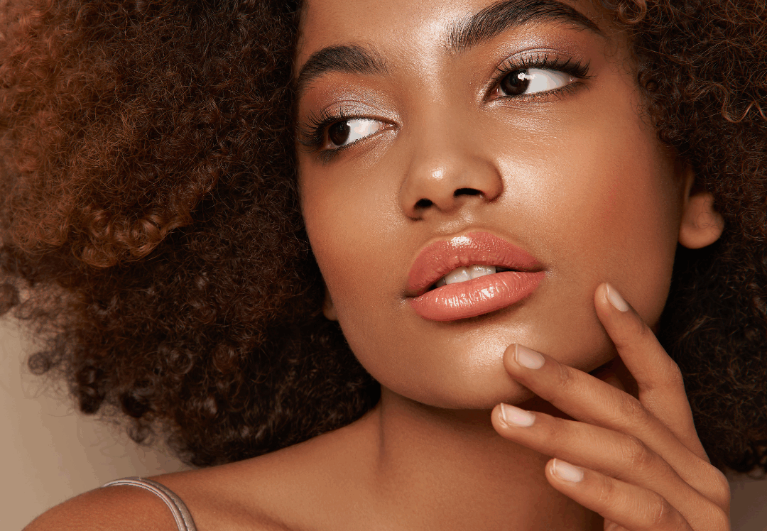 Woman with glowing, lifted skin touching her face, showcasing smooth, youthful results often associated with Ultherapy treatment.