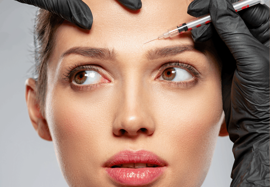 Woman receiving a forehead injection treatment from a gloved provider at a medical spa
