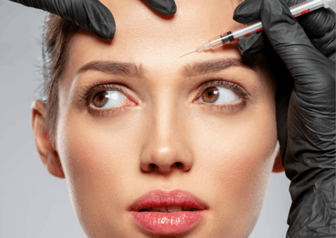 Woman receiving a forehead injection treatment from a gloved provider at a medical spa