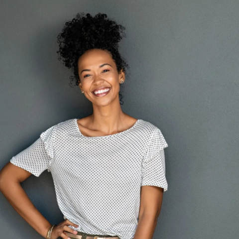 Smiling woman standing against a gray background