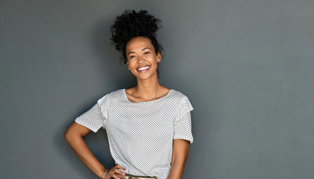 Smiling woman standing against a gray background
