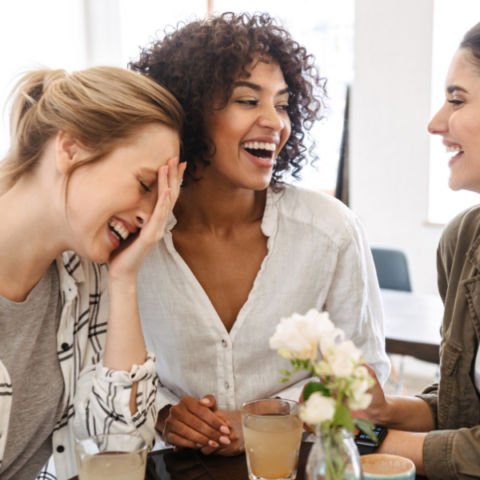 Three women laughing together during a casual conversation
