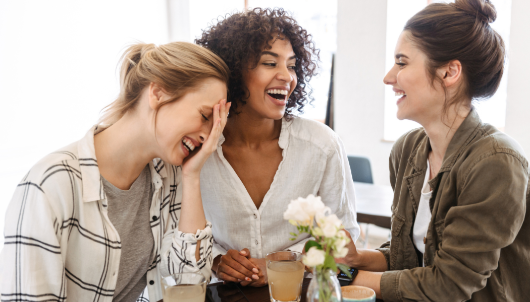 Three women laughing together during a casual conversation